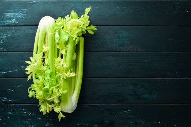 Siyah bir arka plan üzerinde taze yeşil kereviz sapı. Sağlıklı yiyecekler. Üst te. Metniniz için boş alan.