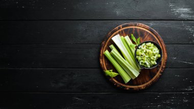 Siyah bir arka plan üzerinde taze yeşil kereviz sapı. Sağlıklı yiyecekler. Üst te. Metniniz için boş alan.