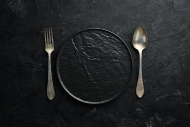 Siyah arka plan üzerinde eski çatal bıçak takımı. Üst te. Metniniz için boş alan.