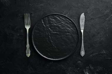 Siyah arka plan üzerinde eski çatal bıçak takımı. Üst te. Metniniz için boş alan.