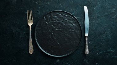 Siyah arka plan üzerinde eski çatal bıçak takımı. Üst te. Metniniz için boş alan.