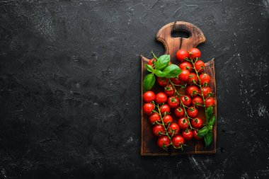 Siyah bir arka plan üzerinde taze kiraz domates. Üst te. Metniniz için boş alan.