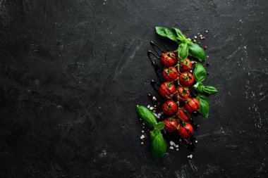 Siyah bir arka plan üzerinde taze kiraz domates. Üst te. Metniniz için boş alan.