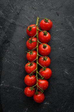 Siyah bir arka plan üzerinde taze kiraz domates. Üst te. Metniniz için boş alan.