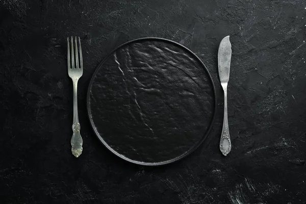 Siyah arka plan üzerinde eski çatal bıçak takımı. Üst te. Metniniz için boş alan.