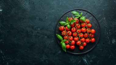 Tabakta kiraz domates ve fesleğen. Üst te. Metniniz için boş alan.