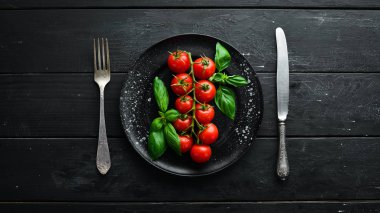 Tabakta kiraz domates ve fesleğen. Üst te. Metniniz için boş alan.