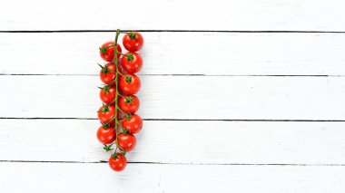 Beyaz ahşap arka planda kiraz domates. Üst te. Metniniz için boş alan.