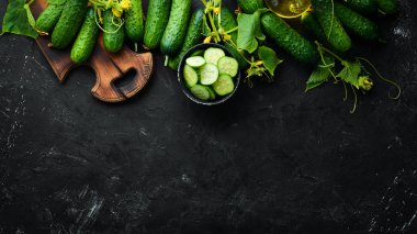 Dilimlenmiş taze yeşil salatalık. Siyah bir arka plan üzerinde. Üst te. Metniniz için boş alan.