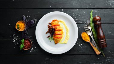 Domatesli tavuk fileto. Tabakta. Ahşap bir arka plan üzerinde. Üst te. Metniniz için boş alan.