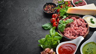 Pişirme sosu Bolognese için Malzemeler. Siyah bir arka plan üzerinde. Üst te. Metniniz için boş alan.
