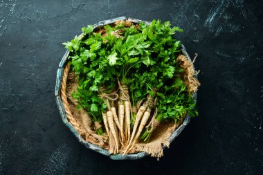 Kök maydanoz ve maydanoz siyah bir arka plan üzerinde. Üst te. Metniniz için boş alan.