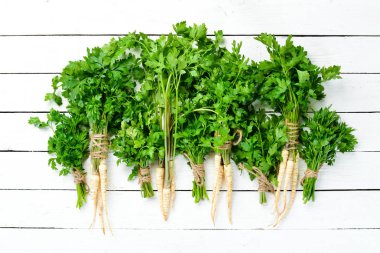 Beyaz ahşap arka plan üzerinde maydanoz kökü. Üst te. Metniniz için boş alan.