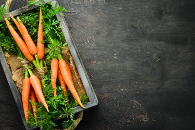 Siyah ahşap arka planda taze havuç. Üst görünüm.