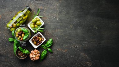 Zeytin, zeytinyağı, baharatlar ve Rustik arka plan üzerinde otlar. Üst te. Metniniz için boş alan.