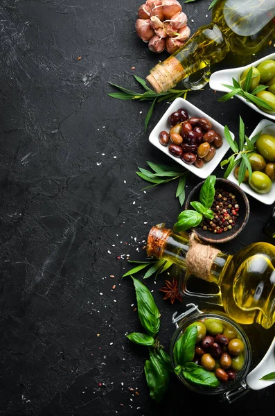 Olives, olive oil, spices and herbs on the Rustic background. Top view. Free space for your text.