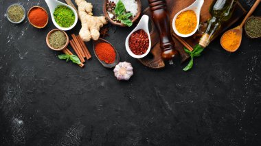 Pişirmek için renkli otlar ve baharatlar. Hint baharatları. Siyah taştan bir arka planda. Üst görünüm.