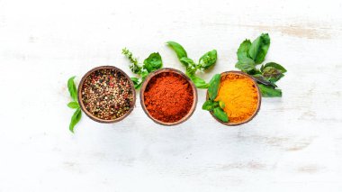 Beyaz arka plan üzerinde bir kase çeşitli baharatlar. Hint baharatları. Üstte görüntü.