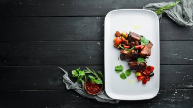 Sebzeli domuz pirzolası. Tabakta. Ahşap bir arka plan üzerinde. Üst te. Metniniz için boş alan.