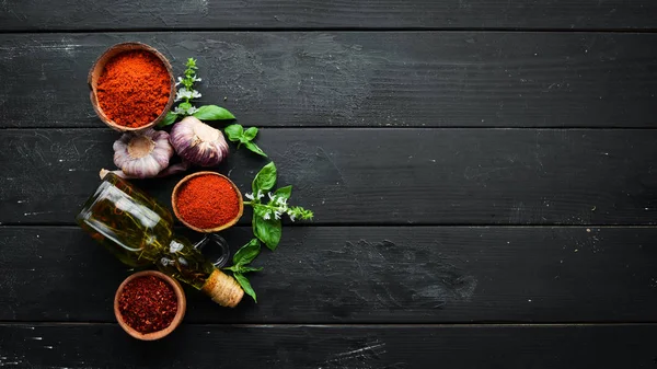 A set of red spices on a black background. Paprika, chili pepper. Top view.