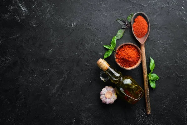 A set of red spices on a black background. Paprika, chili pepper. Top view.