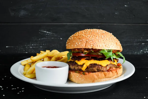 Dana eti, peynir ve sebzeli burger. Fast food. Ahşap bir arka plan üzerinde. Üst te. Metniniz için boş alan.