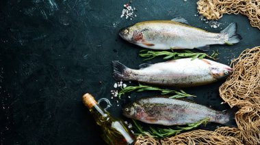 Siyah bir arka plan üzerinde çiğ balık alabalığı. Üst te. Metniniz için boş alan.