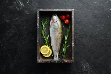 Siyah taş arka planda sebze ile çiğ balık alabalık. Üst te. Metniniz için boş alan.