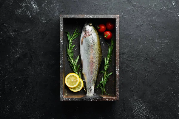 Siyah taş arka planda sebze ile çiğ balık alabalık. Üst te. Metniniz için boş alan.