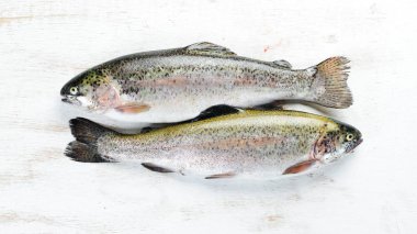 Beyaz ahşap arka planda çiğ balık alabalığı. Üst te. Metniniz için boş alan.