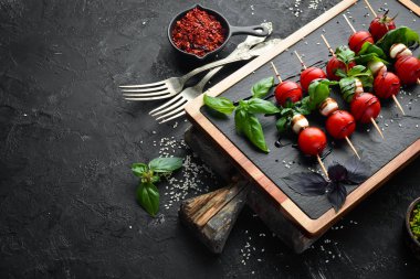 Kiraz domates, mozzarella ve fesleğen. İtalyan atıştırmalıkları. Caprese Üst görünümü. Metniniz için boş alan.