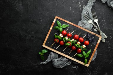 Kiraz domates, mozzarella ve fesleğen. İtalyan atıştırmalıkları. Caprese Üst görünümü. Metniniz için boş alan.