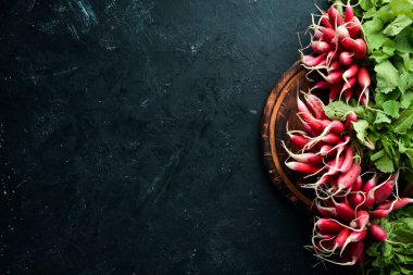 Siyah taş arka planda taze turp. Kırmızı turp üst görünümü.
