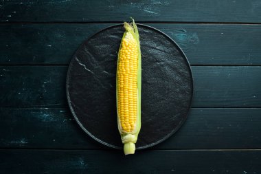 Siyah bir arka planda taze mısır. Sebze. Üst görünüm. Ücretsiz kopya alanı.