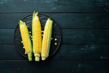 Siyah bir arka planda taze mısır. Sebze. Üst görünüm. Ücretsiz kopya alanı.