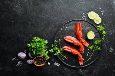 Istakoz pençeleri. Siyah bir arka planda deniz ürünleri. Üst görünüm. Ücretsiz kopya alanı.