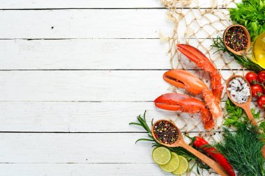 Istakoz pençeleri. Beyaz ahşap arka planda deniz ürünleri. Üst görünüm. Ücretsiz kopya alanı.