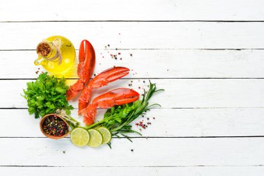 Istakoz pençeleri. Beyaz ahşap arka planda deniz ürünleri. Üst görünüm. Ücretsiz kopya alanı.