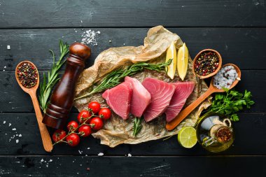 Ham ton balığı fileto. Siyah taş arka planda deniz ürünleri. Üst görünüm. Ücretsiz kopya alanı.