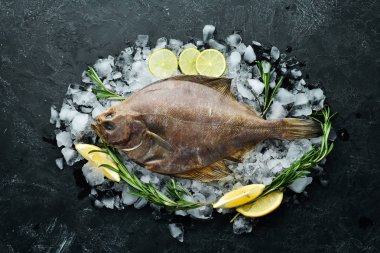 Baharat ile çiğ pisi balığı balık. Siyah taş arka planda deniz ürünleri. Üst görünüm. Ücretsiz kopya alanı.