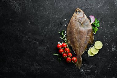Baharat ile çiğ pisi balığı balık. Siyah taş arka planda deniz ürünleri. Üst görünüm. Ücretsiz kopya alanı.