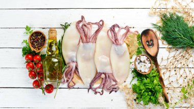 Baharat ile çiğ taze kalamar. Beyaz ahşap arka planda deniz ürünleri. Üst görünüm. Ücretsiz kopya alanı.