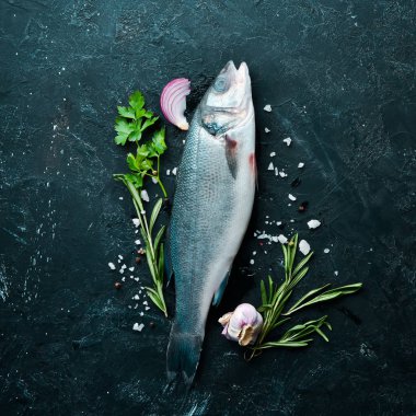 Deniz balığı Levrek. Siyah taş arka planda deniz ürünleri. Üst görünüm. Ücretsiz kopya alanı.