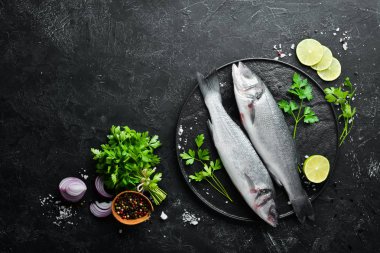 Deniz balığı Levrek. Siyah taş arka planda deniz ürünleri. Üst görünüm. Ücretsiz kopya alanı.