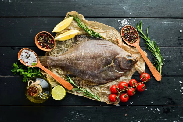 Baharat ile çiğ pisi balığı balık. Siyah taş arka planda deniz ürünleri. Üst görünüm. Ücretsiz kopya alanı.
