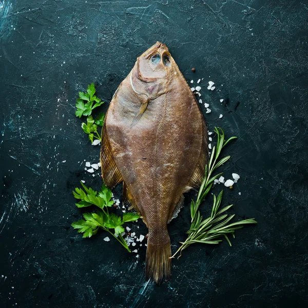 生ヒラメの魚とスパイス 黒い石の背景にシーフード トップビュー 無料コピースペース — ストック写真