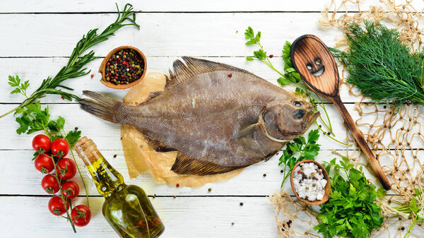 Raw flounder fish with spices. Seafood on a white wooden background. Top view. Free copy space.