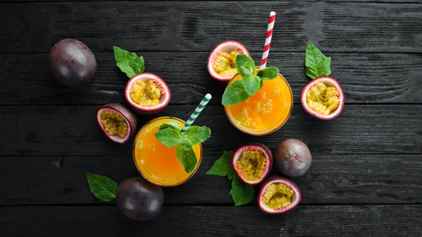 Passion fruits juice and fruits on a wooden background. Tropical Fruits.