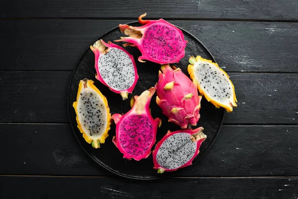 Fresh Dragon Fruit on a Black Background. Tropical Fruits. Top view. Free space for text.