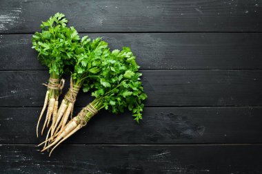 Ahşap bir arka planda kök maydanoz. Üst görünüm. Metniniz için boş alan.